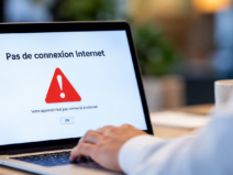 Professionnel utilisant un ordinateur portable affichant un message d’absence de connexion Internet.